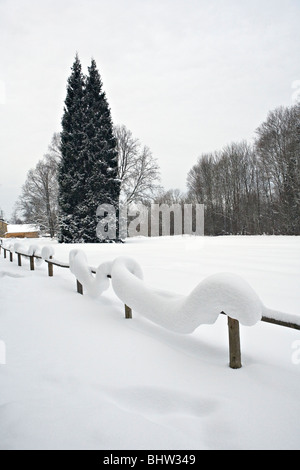 Cumuli di neve sulla recinzione in legno in campagna Allazu in Vidzeme Lettonia Foto Stock