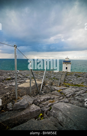 La testina del nero faro con tempeste distanti oltre l'Oceano Atlantico. Foto Stock