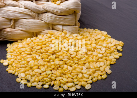 Vivace giallo Moong Daal lenticchie o Mung bean lenticchie contro di ardesia scura. Foto Stock