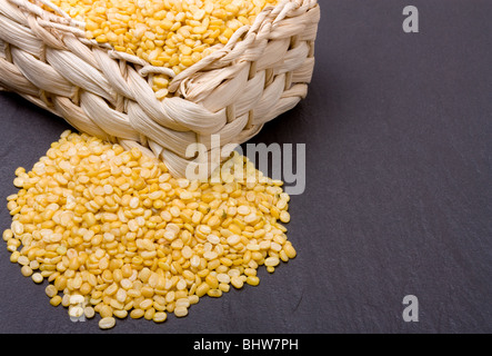 Vivace giallo Moong Daal lenticchie o Mung bean lenticchie contro di ardesia scura. Foto Stock