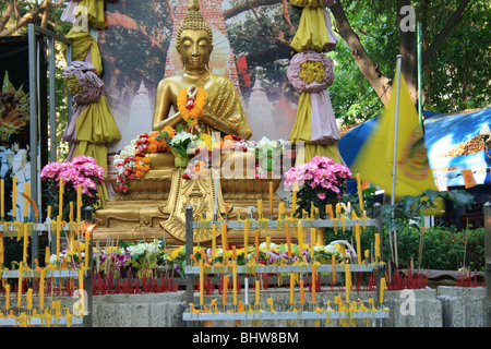 Oro statua del Buddha santuario con candele, Bangkok, Thailandia. Foto Stock