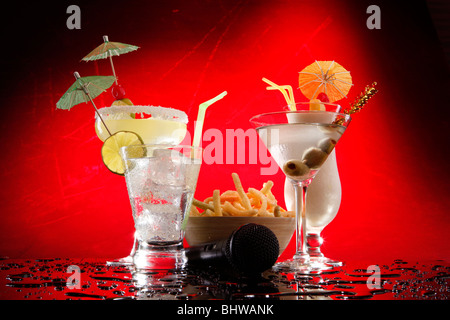 Bevande bianco su rosso, Martini, Margarita, Fizz e Colada con patatine e un karaoke mike Foto Stock