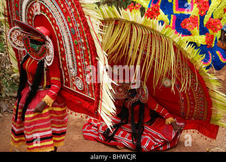 Theyyam forme d'arte appena seduto e rilassante per un po' durante un tempio indù Festival occasione.Scena Theyyattam Kerala, India Foto Stock