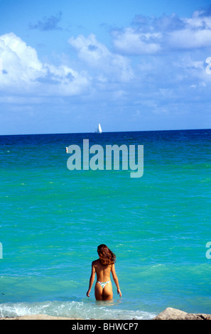Un bikini clad giovane donna entra in acqua oceanica Miami Beach Florida USA Foto Stock
