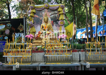 Oro statua del Buddha santuario con candele, Bangkok, Thailandia. Foto Stock