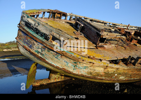 Il marciume scafo di un legname barca da pesca si trova sulla spiaggia. Città Dulas, Anglesey, Regno Unito. Foto Stock