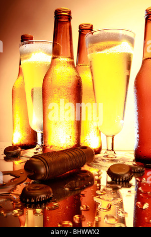 Retro-illuminato golden le bottiglie di birra, occhiali, apriporta e tappi con un vecchio film guardare Foto Stock