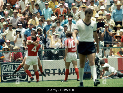 World Cup Quarti di Finale corrispondono a Leon, Messico Inghilterra 2 v Germania Ovest 3 dopo un tempo supplementare Franz Beckenbauer si allontana dejectedly in Inghilterra i giocatori Alan Mullery e Martin Peters celebrare una meta giugno 1970 Foto Stock