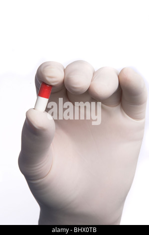 Close up di guanti chirurgici mano azienda pillola Foto Stock