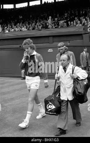 Wimbledon Tennis: Uomini Finals 1981: John McEnroe è scortato sul Centre Court da un portiere portando la sua racchetta e sport Foto Stock