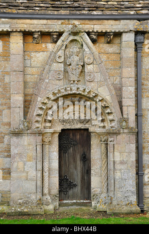 La chiesa di tutti i Santi Lullington nr. Frome , Somerset. La porta Nord Normanna con un timpano raffigurante l'albero della vita. Foto Stock