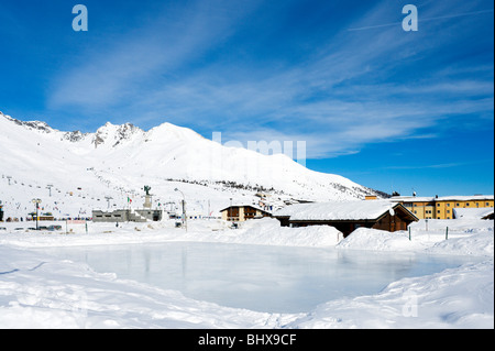 Vista sulla pista di pattinaggio su ghiaccio verso il centro del resort, Passo Tonale, Trentino, Italia Foto Stock