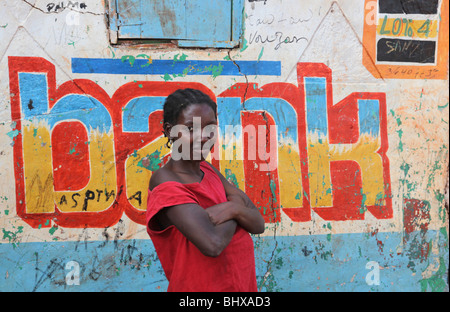 Ritratto di donna al di fuori di un segno della banca, Isola de la Gonave, Haiti Foto Stock