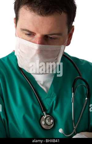 Uomo che indossa medical scrubs e uno stetoscopio che indossa la maschera per il viso Foto Stock