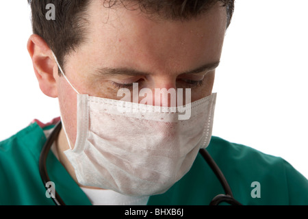 Uomo che indossa medical scrubs e uno stetoscopio che indossa la maschera per il viso Foto Stock