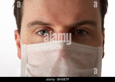 Uomo che indossa indossa la maschera per il viso guardando dritto alla telecamera Foto Stock