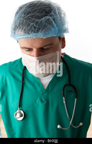 Uomo che indossa medical scrubs e uno stetoscopio che indossa la maschera per il viso e capelli net Foto Stock