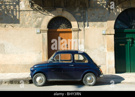 Fiat 500 auto parcheggiate fuori dall'ingresso al tradizionale edificio italiano in Sicilia Foto Stock