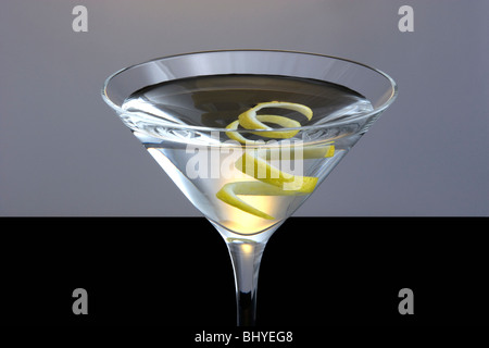 Sempre dritti fino a Martini con il limone Twist guarnire su nero e sfondo grigio Foto Stock