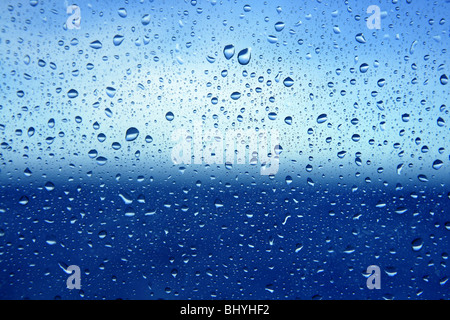 Abstract blu sullo sfondo di gocce di acqua su un vetro in barca lo sfondo della finestra Foto Stock