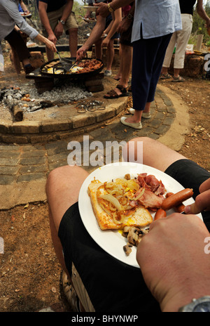 Limpopo, Sud Africa, famiglia di mangiare la prima colazione pasto all'aperto, la cottura di cibo sul fuoco, persone, safari, sfondo, illustrazione Foto Stock