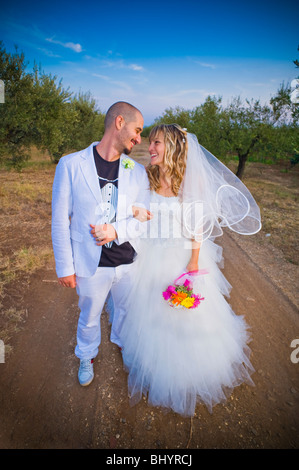 Sposa e lo sposo baciare sulla strada sterrata in vigna Foto Stock