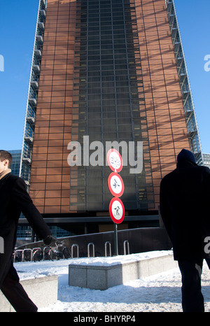 Due uomini a piedi accanto al palazzo Berlaymont, la sede centrale della Commissione europea a Bruxelles, in Belgio. Foto Stock