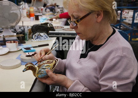 Royal Crown Derby fabbrica, Derby - gilder Julie Towell ultimando un anatra fermacarte. Foto Stock