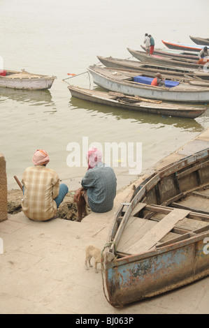 Due uomini seduti e parlare nel rilassante almosphere varanasi's ghats dare i suoi abitanti Foto Stock