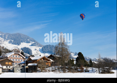 Unico in mongolfiera ad aria calda sopra la città durante il mese di gennaio Balloon Festival, Chateau d'Oex, Vaud, Svizzera Foto Stock