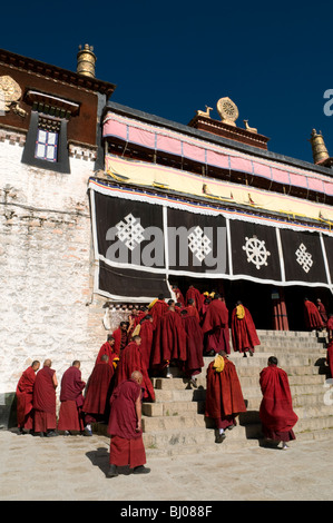 I monaci di fronte nella sala principale di preghiera presso il famoso monastero di Drepung, la più grande a Lhasa il Tibet. Foto Stock