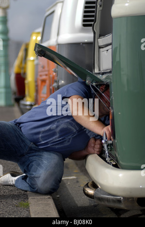 Un appassionato di VW tinkers con la sua VW Camper Van a Brighton Breeze VW Van Rally. Foto Stock