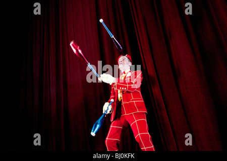 Clown sul palco di eseguire con i club di giocoleria Foto Stock