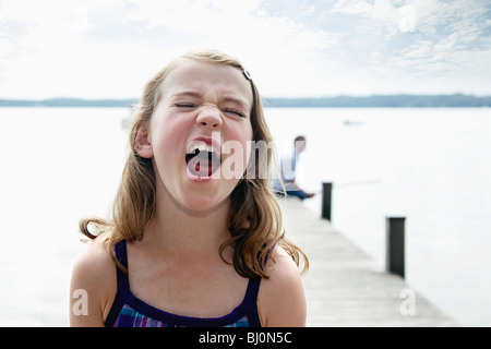 Ritratto di giovane ragazza sul molo urlando Foto Stock