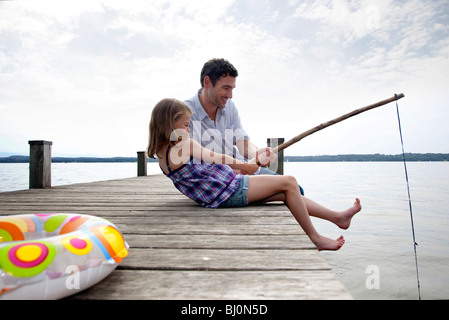 Padre e figlia sul molo pesca sportiva insieme Foto Stock