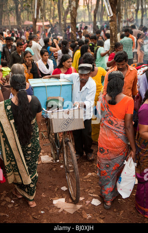 India Kerala, Kanjiramattom Kodikuthu festival musulmano, fornitore spingendo laden bicicletta attraverso la folla Foto Stock