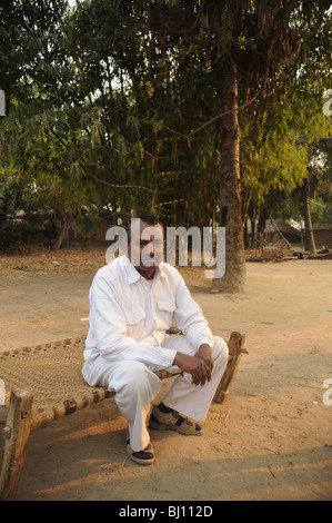 Indian uomo seduto sul letto in un villaggio tradizionale in Bohd Gaya Foto Stock