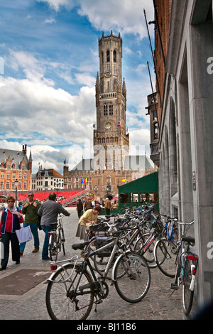 Le Biciclette parcheggiate e gli edifici in luogo di mercato con la Torre Belfry, Bruges, Belgio Foto Stock