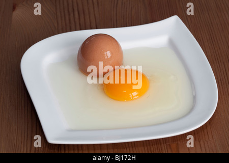 Uovo rotto sulla piastra bianca Foto Stock