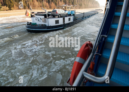 Le navi che passa su ghiaccio laden principale canale del Danubio vicino a Regensburg, Germania Foto Stock