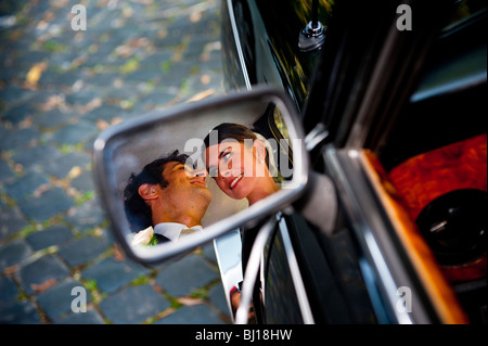 Felice sposa e lo sposo in auto la riflessione speculare Foto Stock