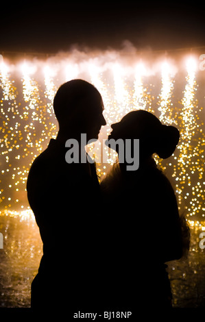 Silhouette della sposa e lo sposo di fronte a fuochi d'artificio Foto Stock