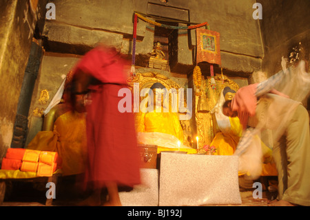 Monaco prega per il Buddha a Bodh Gaya, dove Signore Buddha raggiunto l'illuminazione sotto il Bodhi Tree, India Foto Stock