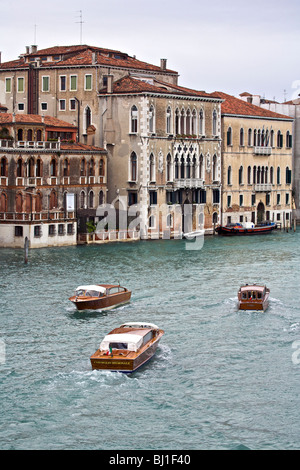 Tre barche a motore fanno il loro cammino lungo il Canal Grande a Venezia, Veneto, Italia Foto Stock