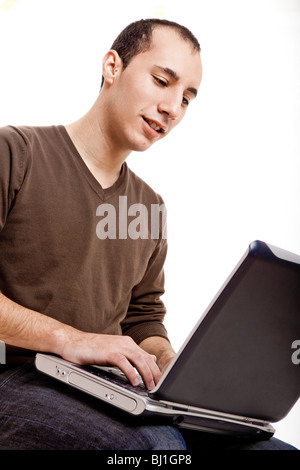 Giovane uomo che lavora su un notebook, isolato su bianco Foto Stock