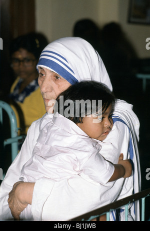 Madre Teresa di Calcutta che abbracci un bambino alla sua missione di aiuto poveri e affamati, Calcutta, India Foto Stock