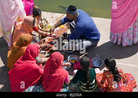 Pellegrini indù facendo una offerta rituale (puja). Brahma Ghat. Lago di Pushkar. Il Rajasthan. India Foto Stock