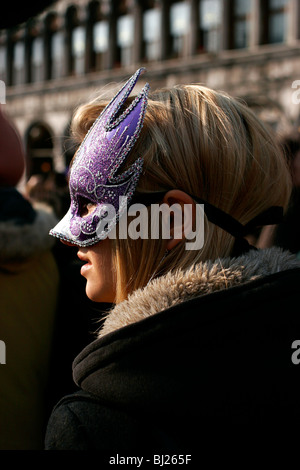 Ragazza bionda durante il Carnevale di Venezia con una maschera viola Foto Stock