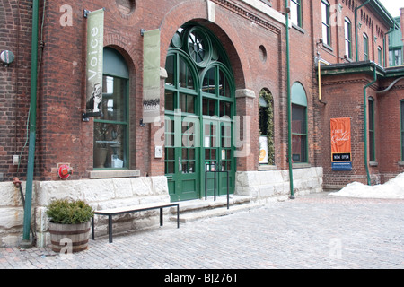 Un vecchio edificio in mattoni rossi con grande verde della porta d'ingresso Foto Stock