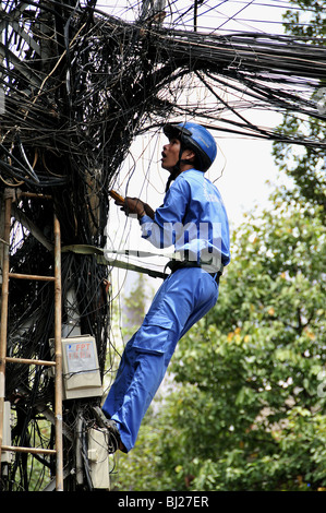 Città lavoratore fino un polo Controllo di cavi in Ho Chi Minh City, Vietnam Foto Stock